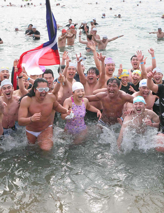 ２０日、釜山（プサン）の海雲台（ヘウンデ）海水浴場で「第２６回ホッキョクグマ水泳大会」が開かれ、参加者が水遊びをしている。