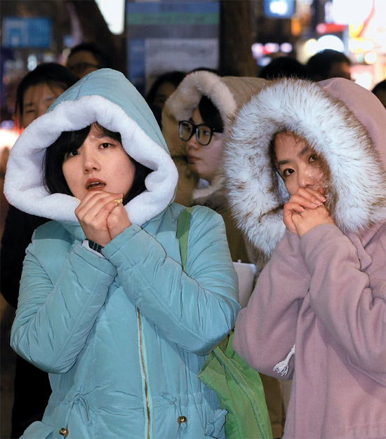 ６日夜、ソウル・鍾路（チョンロ）２街のバス停で市民が体をすくめながらバスを待っている。