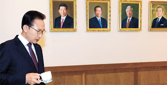 李明博大統領が１９日午前、青瓦台で最後の閣議を主宰するのに先立ちお茶を飲みながら考えにふけっている。閣議終了後、歴代大統領の肖像画がかけられている世宗（セジョン）前室に李大統領の肖像画も盧武鉉前大統領の肖像画の左側にかけられた。（青瓦台写真記者団）