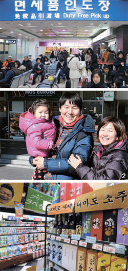 観光客が釜山旅客ターミナルで、インターネットやデパート免税店であらかじめ購入した商品を受け取っている（写真上）。 日帰りの対馬旅行に来た夫婦が娘と一緒に厳原のハンバーガー店で昼食を終えた後、笑顔を見せている（写真中）。 厳原のスーパーにある韓国語の商品案内（写真下）。  