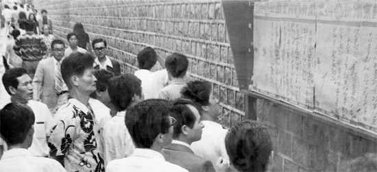 ソウル市民が１９７４年８月２３日、緊急措置１、４号の解除を知らせる掲示物を見ている。令状なしに人身拘束を可能にする緊急措置１号は同年１月に発動された。（写真＝中央日報）。