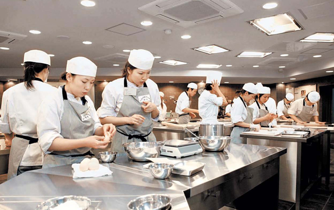大阪の辻調本校の「エコール辻」で、学生たちが製菓の授業を受けている。（写真＝辻調）