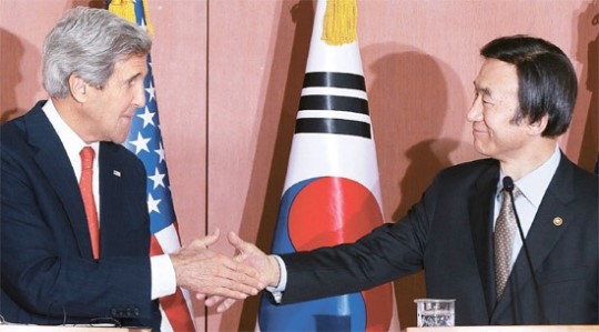 尹炳世（ユン・ビョンセ）外交部長官（右）とジョン・ケリー米国務長官が１２日、韓米外相共同記者会見の前に握手している。