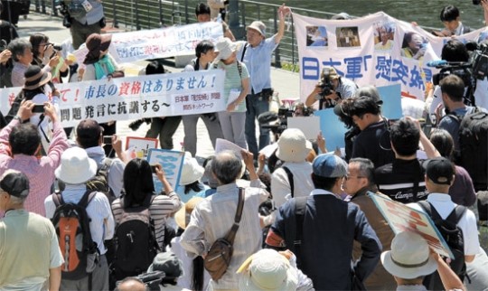 日本軍慰安婦関連市民団体の会員が２４日、日本大阪市役所の前で橋下徹大阪市長の妄言を糾弾し、辞任を求める抗議デモを行なっている。現場では日本右翼団体の会員が「反日勢力は日本から出て行け。慰安婦はなかった」と書かれた紙を持ってデモを行った。