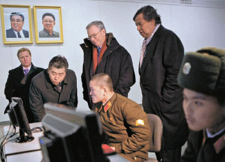 １月８日、北朝鮮平壌（ピョンヤン）の金日成総合大学を訪問したエリック・シュミット グーグル会長とビル・リチャードソン元米ニューメキシコ州知事（後列の左から２人目と３人目）が、学生がグーグルで資料を検索する姿を見ている。