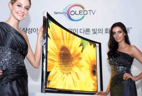 サムスン電子のモデルが２７日、ソウルのサムスン電子瑞草（ソチョ）社屋で５５インチの曲面有機発光ダイオード（ＯＬＥＤ）テレビを公開した。（写真＝サムスン電子）
