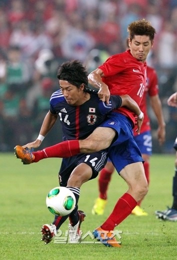 東アジアカップ２０１３男子第３戦の韓国対日本戦で、河大成（ハ・デソン）が山田大記と激しいボール争いを繰り広げている。