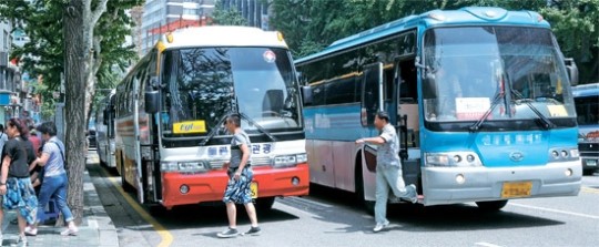 外国人観光客が先月２６日午後、ソウル西小門洞の飲食店の前に二重停車した観光バスから降りている。これより先に観光客を降ろした左側の観光バスは一つの車道を占領している。