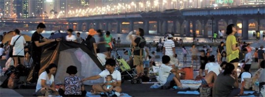 ８日夜、ソウル汝矣島（ヨイド）の漢江（ハンガン）市民公園で涼んでいる市民。