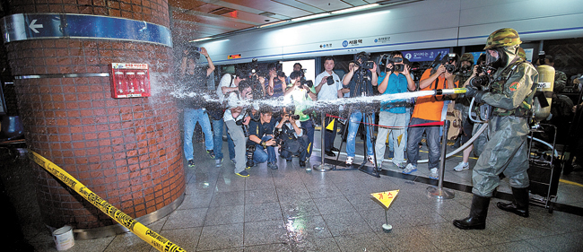 昨年の合同演習で化学兵器隊員が地下鉄駅で除毒剤を散布している。