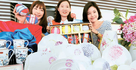ソウル清渓（チョンゲ）の社屋店舗で、モデルが韓紙で包装した伝統礼物セットと菊やあじさいなどのデザインがあしらわれた礼物用食器を見せている。