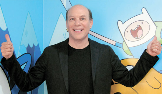 カートゥーンネットワークスタジオのブライアン・ミラー代表が人気アニメ『アドベンチャータイム』のキャラクターの前で明るく笑っている。