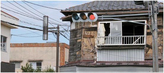 福島原子力発電所から８キロメートルほど離れた浪江町のある民家。家の持ち主がここを離れて２年半が流れたせいか、カーテンが裂けて窓ガラスがなくなり、外装の板も剥がれてしまっている。