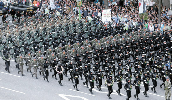 第６５周年「国軍の日」を迎えた１日午後、徒歩や機械化部隊による行進がソウル世宗路（セジョンノ）一帯で行われた。海軍最精鋭の特殊部隊ＵＤＴ／ＳＥＡＬ隊員が市民の拍手を受けて徳寿宮（トクスグン）の前を行進している。この日の市街行進には、国軍４５００人余りと１０５台の最新軍事装備が参加して精鋭強軍の威容を見せた。韓国軍の都心における市街行進は１０年ぶりだ。