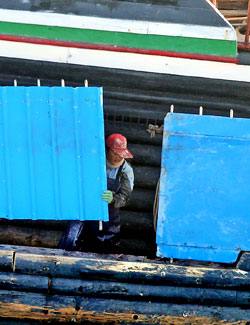 中国漁船の船員が鋭い鉄串が付いた鉄板を設置している。