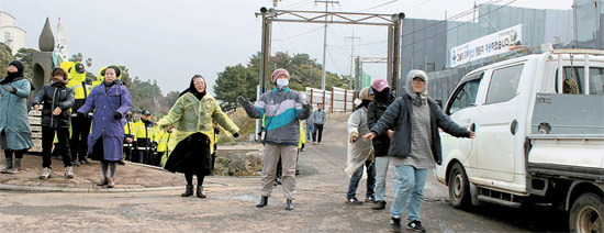 ２７日午後、済州海軍基地建設反対ミサ直後に出席者が民衆歌謡に合わせ踊っている。レインコートを着た修道女も参加した。