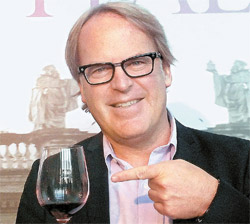 ジェームズ・サックリング氏が「今年のイタリアワイントップ１０」の試飲会場入口でワイングラスを持っている。