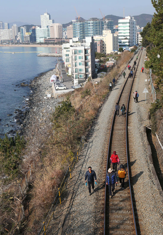 ８日、釜山市民が海雲台の秘境を鑑賞しながら線路に沿って歩いている。