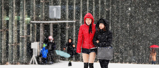 １２日午後、ソウル新村（シンチョン）の梨花（イファ）女子大学の校庭で雪の中を歩いている学生。