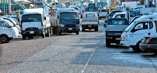 車線が消えた仁川沿岸埠頭路１１５番。１年が過ぎても予算不足のため車線が引かれていない。道路は無秩序な駐車場に変わっている。