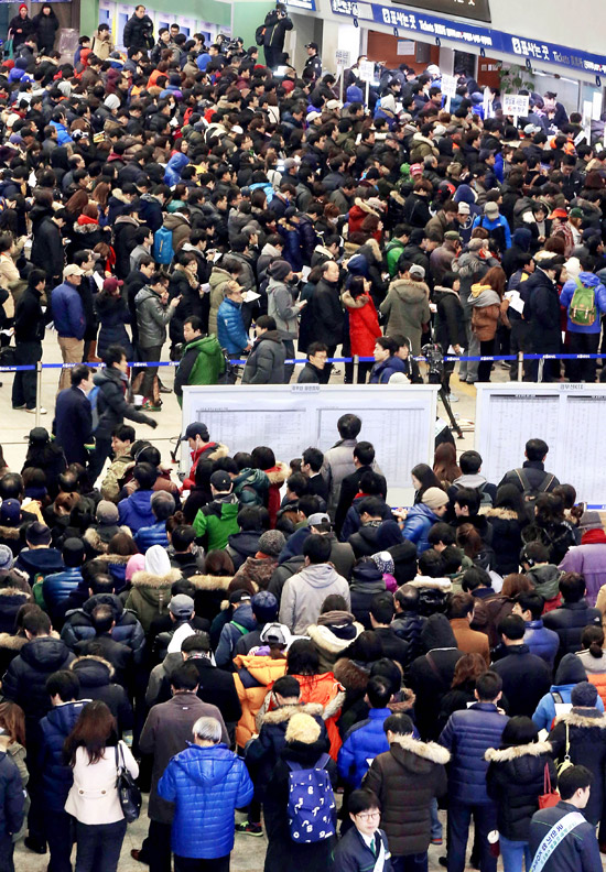 ８日、旧正月（ソルラル）の帰省列車乗車券の現場前売りのため、ソウル駅で長い行列をつくっている市民。