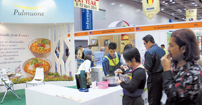 昨年４月、アラブ首長国連邦で開かれたハラールミドルイースト展示会で現地の人たちが韓国企業の食品を味わっていた。（写真＝社団法人ハラール協会）