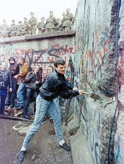 １９８９年１１月、ドイツ市民がハンマーでベルリンの壁を壊している。６１年に東ドイツ政府が築いた壁が崩れるまで３８年がかかった。