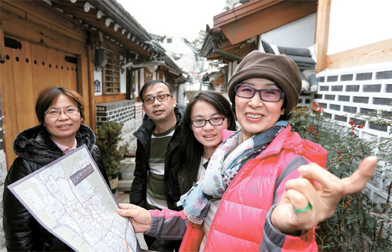先月２３日、ソウルの北村（プクチョン）韓屋村（ハノクマウル）で、詩人で小説家のハン・グィナムさんが中国人観光客の家族を案内している。ハンさんは２年前に外国人向けゲストハウスをオープンした。