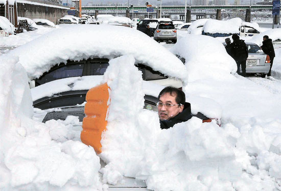 江原道嶺東（カンウォンド・ヨンドン）地域に９日まで４日連続で大雪が続いている。４日間で８０．５センチ（９日午後１０時現在）の雪が降った江陵（カンヌン）市内では車の上の雪かきをしている。気象庁は大雪が１０日まで続いて山間地域には１０～３０センチの雪がさらに降ると予報した。