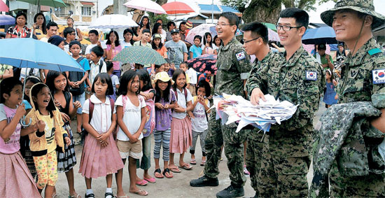 １３日（現地時間）、フィリピン・レイテ州のセントラル小学校復旧完了の行事でこの学校の子供たちが韓国部隊の隊員に感謝の手紙を渡している。（写真＝合同参謀本部）
