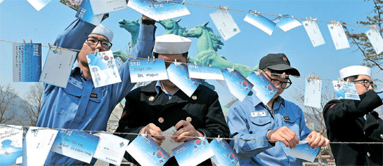 ２４日、追悼式が開かれる国立大田顕忠院の太極旗通りで参拝客が書いた追悼メッセージカードをつるしている海軍の将兵。