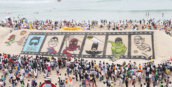 昨年６月、釜山（プサン）の海雲台（ヘウンデ）海水浴場で開かれた砂祭りに集まった観覧客。今年はセウォル号惨事の犠牲者を追悼するため大々的なパレードはしないが、砂の彫刻展など見どころは豊富だ。（写真＝中央フォト）