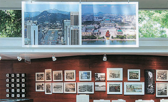 今年のベネチア・ビエンナーレ国際建築展で公開された韓国館の展示「韓半島烏瞰図」は南北の建築状況を多様な角度から光を当てた。展示場内にはソウルと平壌を対比させた２枚の大きな写真が目立つ。左側の写真は「世宗路」（シン・ギョンシク撮影）、右側は平壌の金日成広場（フィリップ・マウザー撮影）だ。（写真＝韓国文化芸術委員会）