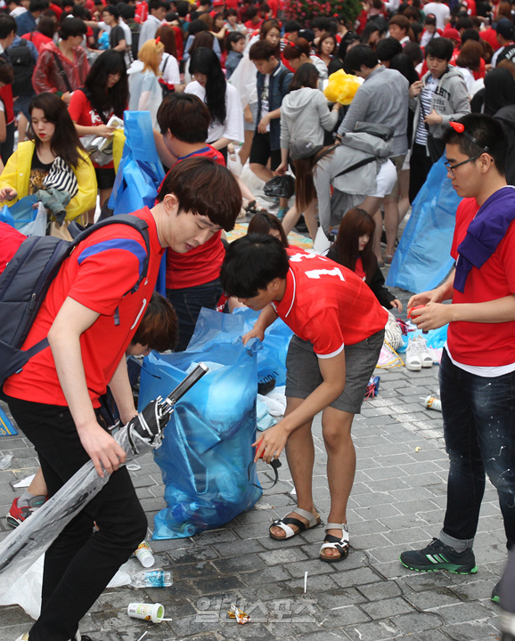 ２３日、ソウル光化門広場での試合観戦後、ゴミを片付けている韓国代表の応援団。