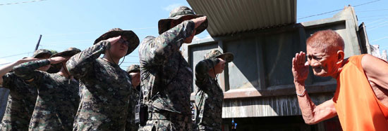 アラウ（Ａｒａｗ）部隊の将兵たちが２４日、レイテ州タクロバン市で復旧作業をする前に韓国戦に参戦した勇士ドミンゴ・アガスを訪ねて報恩の敬礼で礼を尽くしている。