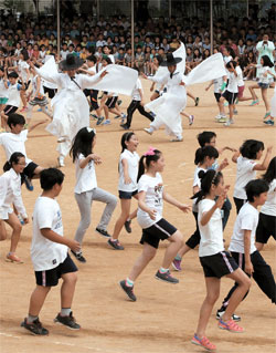 ２日釜山市金井区（プサンシ・クムジョング）の斗実（ドゥシル）小学校は学校・家庭・地域社会が参加する体験中心の斗実人性（人格）文化祭を開催した。子供たちが東莱鶴（トンレハク）踊りの伝授者らと共に運動場で東莱鶴踊りを舞っている。