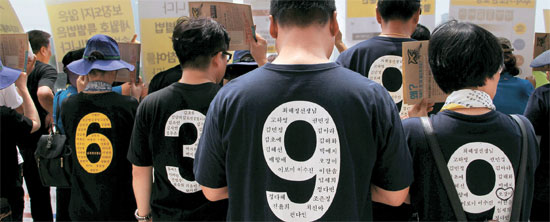 １４日、旅客船セウォル号惨事の被害者家族らが檀園高犠牲者の名前と学級番号が書かれたＴシャツを着て国会本庁前で記者会見をしている。