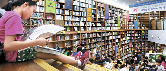 ソウル地域の昼間の気温が３０度を超えた８日午後、夏休みでソウル図書館を訪れた子供たちが本を読みながら暑さをしのいでいる。