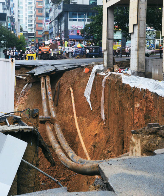 １８日午後、釜山のあるマンション新築工事現場で鉄骨構造物とその横の道路が崩壊した。