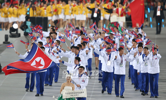 国旗を振りながら入場する北朝鮮の選手