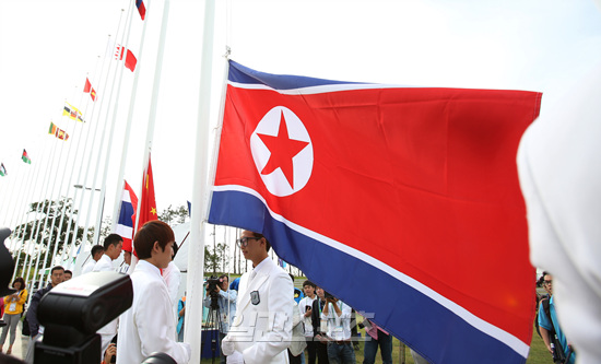 ２０１４仁川アジア競技大会に出場する北朝鮮選手団第４陣４１人が２２午後、仁川国際空港を通じて入国する。写真は１８日、入村式を行い国旗広場で北朝鮮国旗を掲揚中の北朝鮮選手。