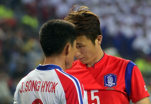 ２日、仁川（インチョン）文鶴競技場で開かれた２０１４仁川アジア競技大会男子サッカー決勝戦の試合の途中で、にらみ合いをしている北朝鮮のチャン・ソンヒョク（左）と韓国のイム・チャンウ。