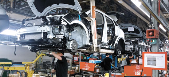 英サンダーランドにある日産「キャシュカイ」生産工場で、工場の職員がエンジンを自動車に搭載した後、点検している。