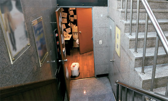 ソウル大学路（テハンノ）のＡ小劇場の出入口。地下１階の公演会場と地上をつなげる通路は、このドアと階段だけ。７０席の客席を満たした観客や俳優・スタッフらが非常状況で一度に脱出するにはあまりにも狭い。公演法上、「登録」の必要がない客席１００席未満の小劇場は、安全管理において一層貧弱な状態だ。