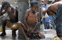 エチオピアに造成された「地球村セマウル運動　モデル村」のアドゥララで昨年９月、水道から勢いよく出る水を浴びて喜んでいる子供たち。（写真＝安全行政部）