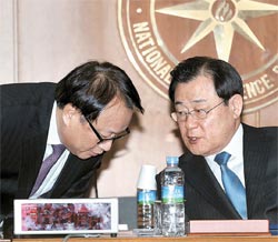 韓国国家情報院に対する国会の情報委員会国政監査が２８日、非公開で行われた。李丙ギ（イ・ビョンギ）国家情報院長（右）が国政監査開始に先立ち、ハン・ギボム第１次長と話を交わしている。