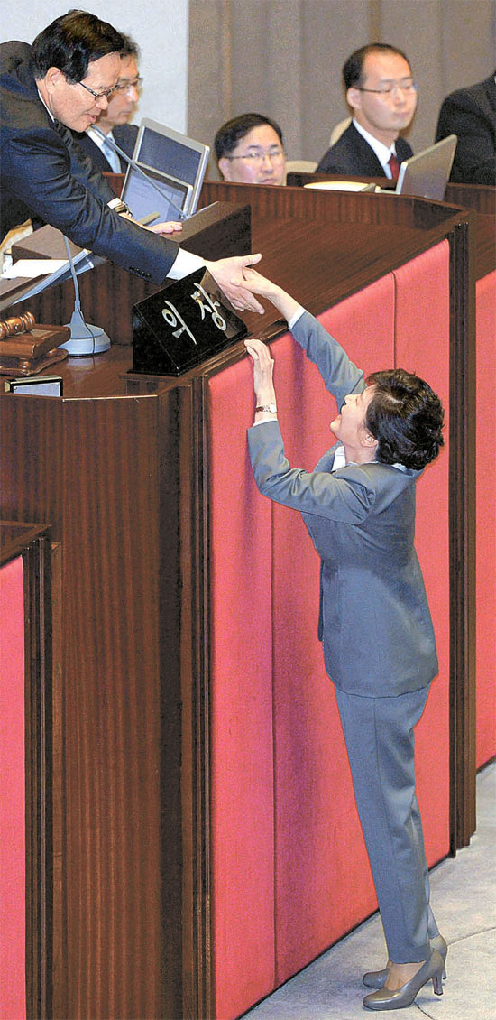 朴槿恵大統領が２９日、国会本会議場で予算案施政演説を終えた後、鄭義和国会議長と握手している。朴大統領は演説で国会と政府、国民と企業がひとつになって経済回復に総力を尽くそうと訴えた。（写真＝青瓦台写真記者団）