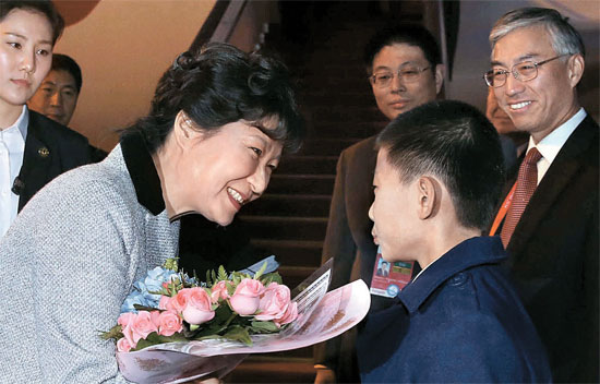 ＡＰＥＣ首脳会議に出席するため朴槿恵大統領が９日に北京首都空港に到着して中国の少年から歓迎の花束を受けている。