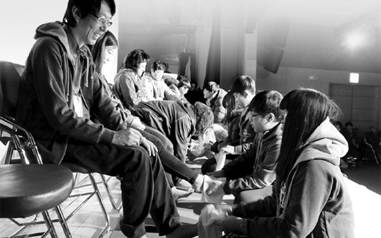 ２７日に国会人格教育実践フォーラムが開催したキャンプで、生徒が親の足を洗っている。（写真＝人性フォーラム）