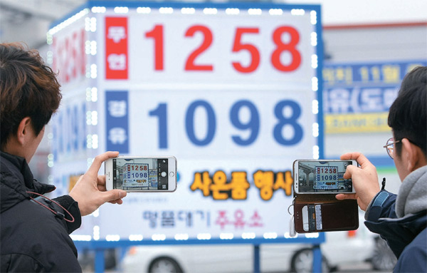 ２１日、全国最安値を記録した大邱市魯院洞３街のガソリンスタンドで会社員が価格表の写真を撮影している。